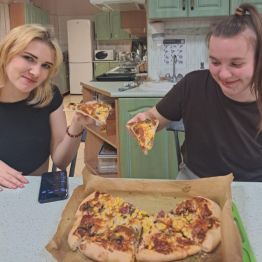 Wychowanki spożywają pizzę, którą same zrobiły.
