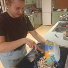 Dziewczynka przygotowuje farsz z pieczarek .