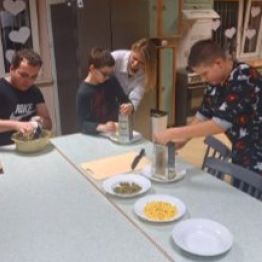 Wychowankowie tworzą swoją pizzę.