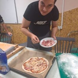 Wychowanek nakłada produkty na swoją pizzę.