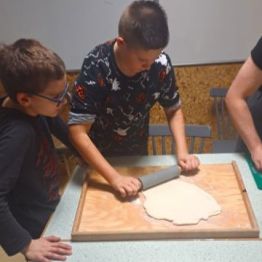 Chłopiec wałkuje ciasto.