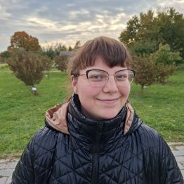uśmiechnięta dziewczyna na tle drzew