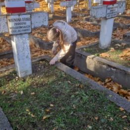 Uczennica pielęgnuje grób żołnierza