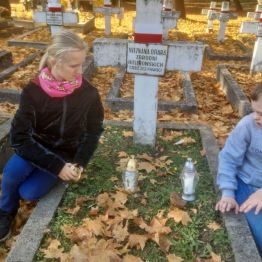 Dzieci modlą się przy grobie żołnierza