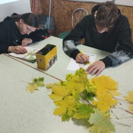 Młodzież przygotowuje prace plastyczne i klei jesienne liście