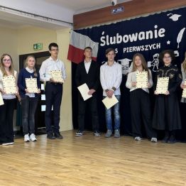 Uczniowie technikum stoją na scenie z dyplomami 