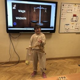 Uczennica klasy 1 b eksponuje własnoręcznie wykonaną wagę.