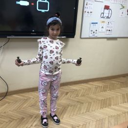 Uczennica klasy 1 b eksponuje własnoręcznie wykonaną wagę.