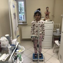 Uczennica klasy 1b podczas ważenia w gabinecie pielęgniarki.