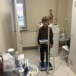 Uczeń klasy 1b podczas ważenia w gabinecie pielęgniarki.