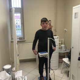 Uczeń klasy 1b podczas ważenia w gabinecie pielęgniarki.