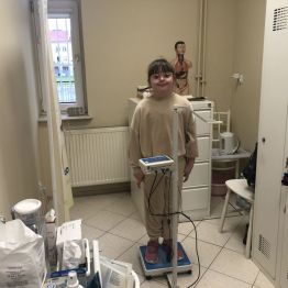 Uczennica klasy 1b podczas ważenia w gabinecie pielęgniarki.