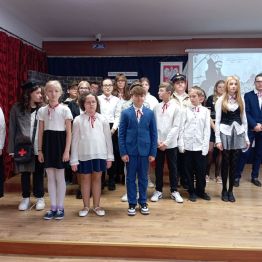 uczniowie występujący w akademii stoją na scenie 