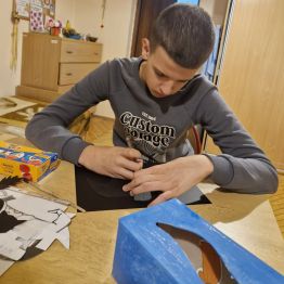 Wychowanek odrysowuje elementy na imprezę Andrzejkową