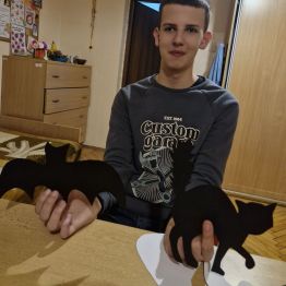 Wychowanek pozuje z wykonanymi wcześniej dekoracjami Andrzejkowymi