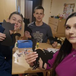 Wychowawca z wychowankami pozuje z wykonanymi wcześniej dekoracjami Andrzejkowymi- kotami, nietoperzami itp.