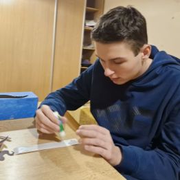 Wychowanek przykleja elementy na "magiczne pudełko".