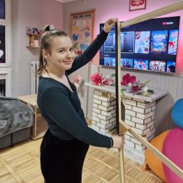 Wychowanka pomaga przy stworzeniu fotobudki Andrzejkowej