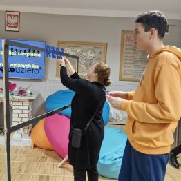 Wychowanek pomaga wychowawcy przy tworzeniu fotobudki Andrzejkowej