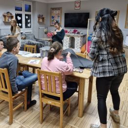 Wychowawca tłumaczy wychowankom, co muszą przygotować krok po kroku