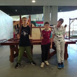 Trzech chłopców z eksponatami w rękach.