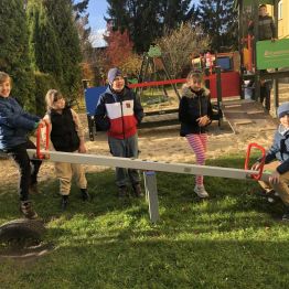 Uczniowie klasy 1b i 3a podczas dokonują pomiaru ciężaru własnego ciała przy użyciu huśtawki na placu szkolnym. 