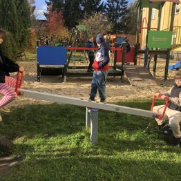 Uczniowie klasy 1b i 3a podczas dokonują pomiaru ciężaru własnego ciała przy użyciu huśtawki na placu szkolnym. 