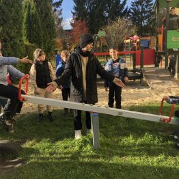 Uczniowie klasy 1b i 3a podczas dokonują pomiaru ciężaru własnego ciała przy użyciu huśtawki na placu szkolnym. 