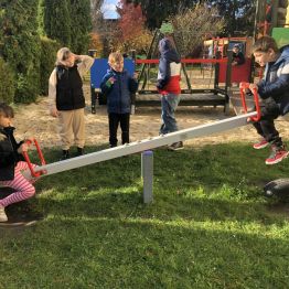 Uczniowie klasy 1b i 3a podczas dokonują pomiaru ciężaru własnego ciała przy użyciu huśtawki na placu szkolnym. 