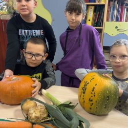 Dzieci oglądają warzywa na zupę dyniową. 