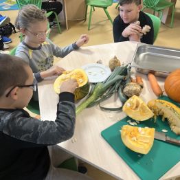 Dzieci przygotowują warzywa na zupę dyniową. 