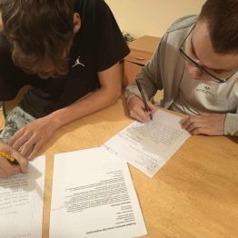 chłopcy piszą ręcznie podanie o pracę