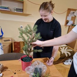 Wychowanki umieszczają elementy stroika w doniczce.
