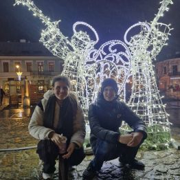 Wychowankowie pozują na tle świątecznej instalacji świetlnej 