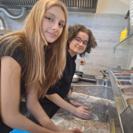 Uczennice ugniatają ciasto na pizzę