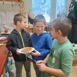 Uczniowe trzymają talerz z misowymi pancakes.