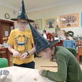 Chłopcy przy stole z ciasteczkowymi wróżbami.