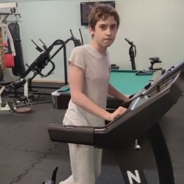 Chłopiec ćwiczy na siłowni