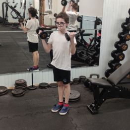 Chłopiec ćwiczy na siłowni