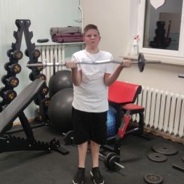 Chłopiec ćwiczy na siłowni