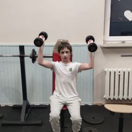 Chłopiec ćwiczy na siłowni