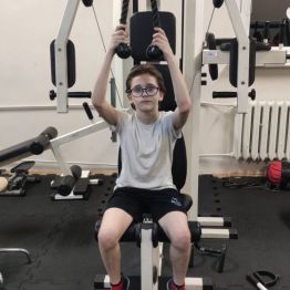 Chłopiec ćwiczy na siłowni