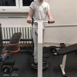 Chłopiec ćwiczy na siłowni