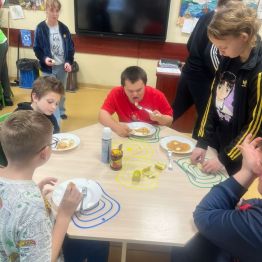 Grupa uczniów przygotowuje i konsumuje misiowe pancakes. 