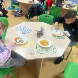 Uczniowie konsumują misiowe pancakes. 