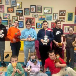 Uczniowie z pluszowymi maskotkami.