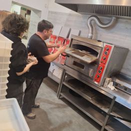 Szef kuchni umieszcza pizzę w piecu