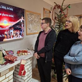 Wychowawca wraz z wychowankami śpiewa kolędę. 