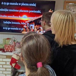 Wychowawca wraz z wychowankami śpiewa kolędę. 