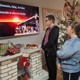 Dziewczynka i chłopiec wspólnie śpiewają kolędę.